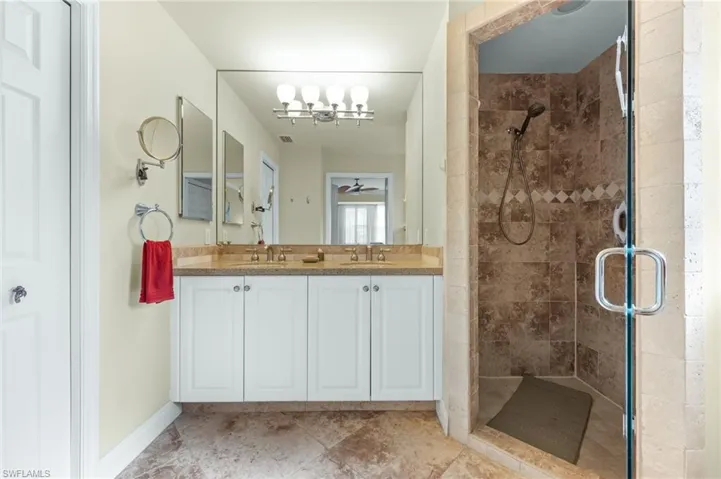 Full bath with double vanity and a stall shower