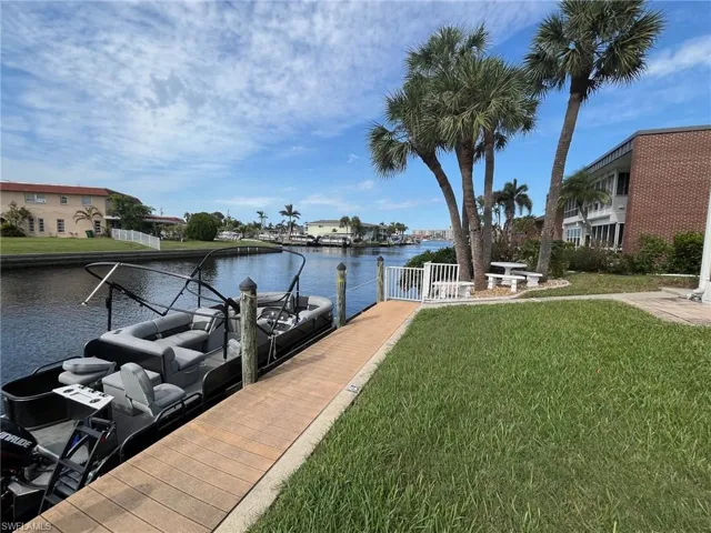 Dock area with a water view and a yard