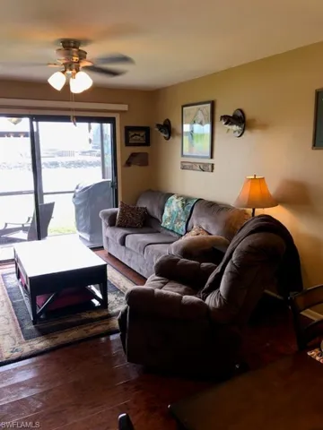 Living room featuring ceiling fan and wood-type flooring