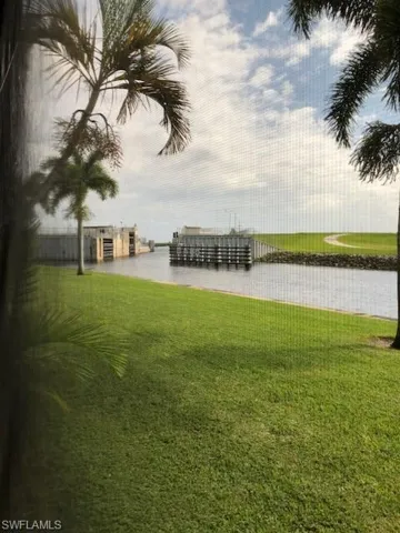 View of yard with a water view and a dock