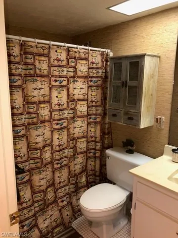 Bathroom featuring tile patterned flooring, vanity, and toilet