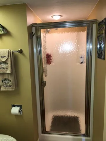 Bathroom with toilet and a shower with door