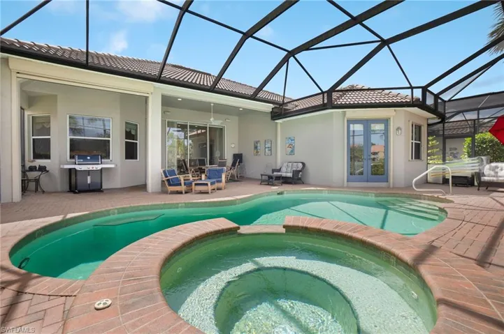 View of swimming pool with ceiling fan, french doors, an in ground hot tub, a patio, and a lanai