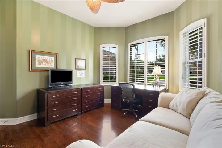 Home office featuring dark hardwood / wood-style floors and ceiling fan