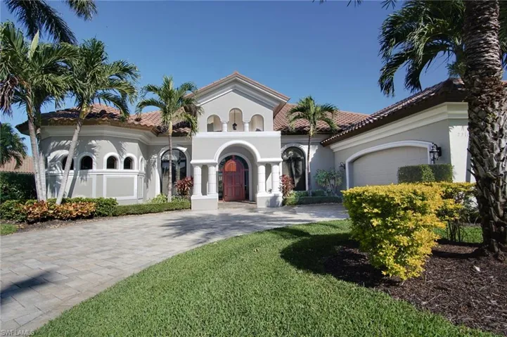 Mediterranean / spanish home featuring a front lawn and a garage