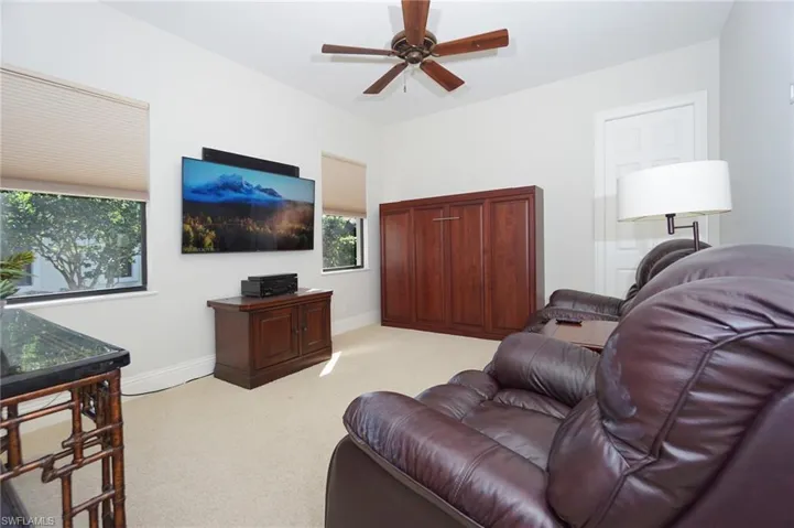 Carpeted living room with ceiling fan