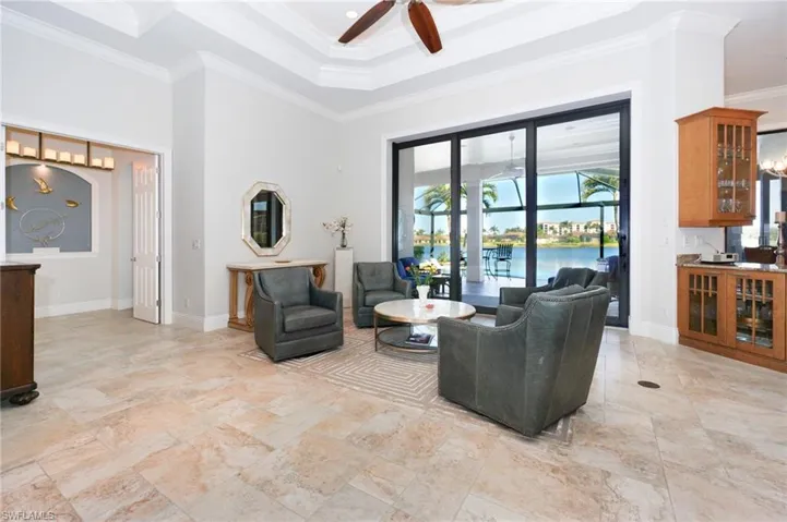 Living room with a water view, ceiling fan, and ornamental molding