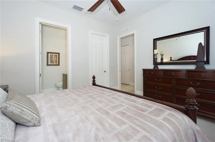 Bedroom featuring connected bathroom and ceiling fan