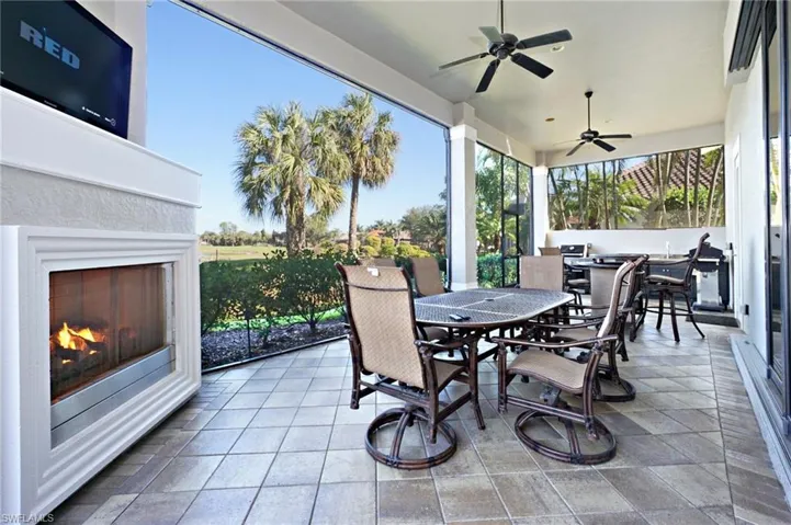View of patio with ceiling fan and an outdoor fireplace