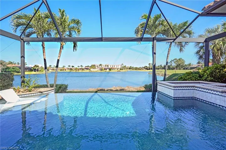 View of swimming pool with a jacuzzi, a water view, and glass enclosure