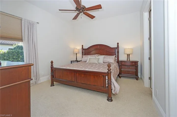 Bedroom with light colored carpet and ceiling fan