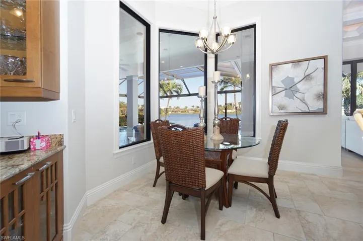 Dining room with plenty of natural light, a water view, and a notable chandelier