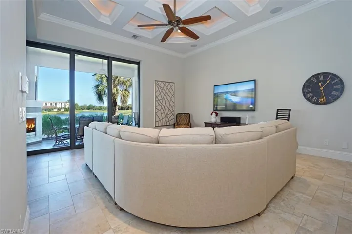 Living room with beam ceiling, crown molding, ceiling fan, and coffered ceiling