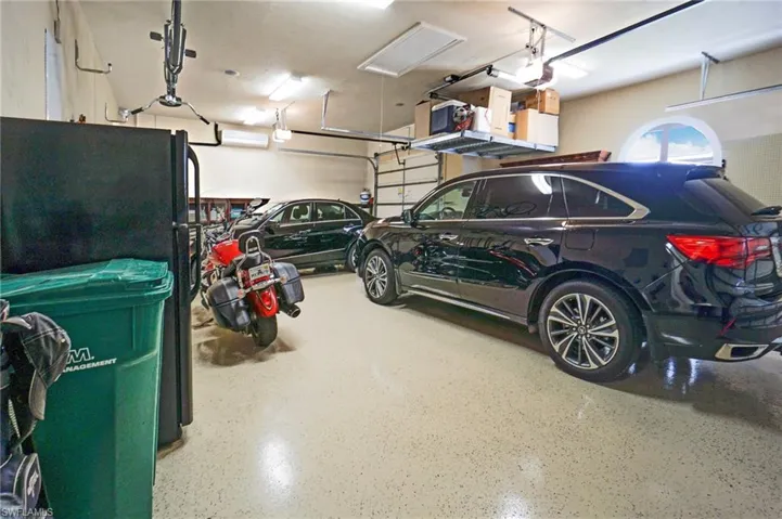 Garage with black refrigerator and a garage door opener