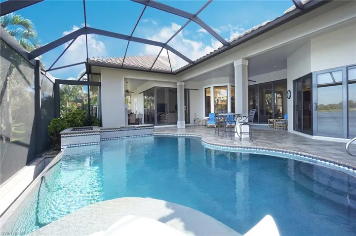 View of pool featuring a lanai, ceiling fan, a patio, and a jacuzzi