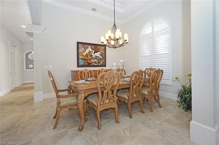 Dining space with crown molding and a chandelier