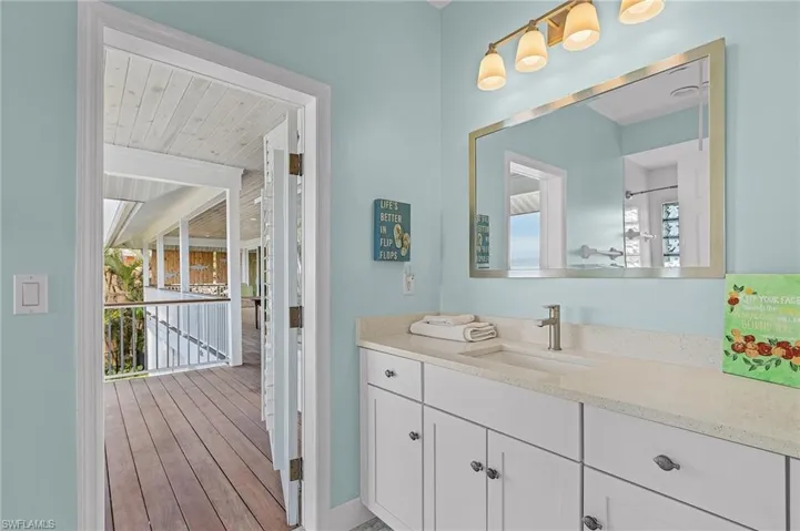 Bathroom with vanity and wood-type flooring and exit to outside