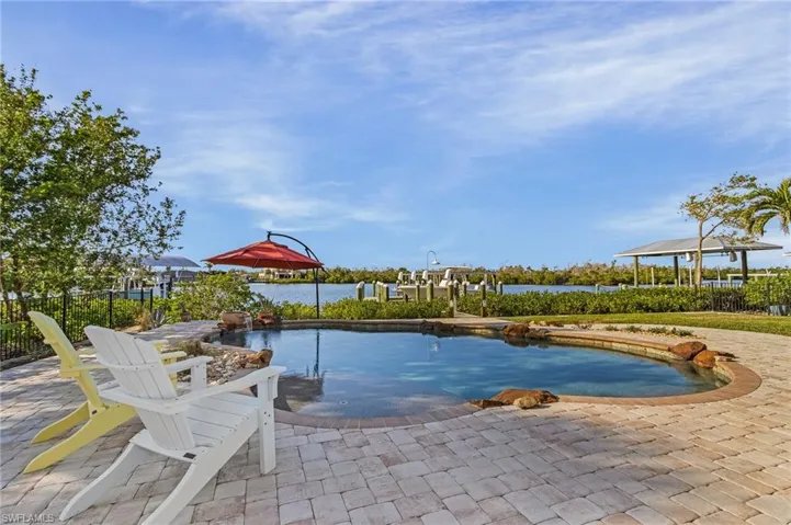 View of swimming pool featuring a water view and a patio