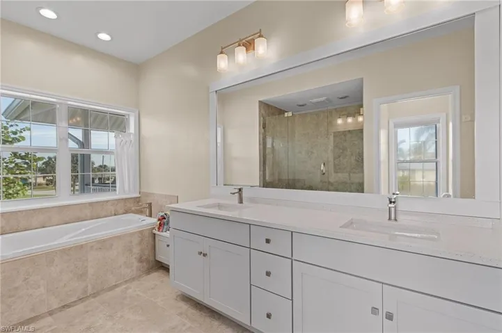 Bathroom featuring vanity and independent shower and bath