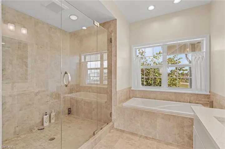 Bathroom with plus walk in shower, vanity, and tile patterned floors