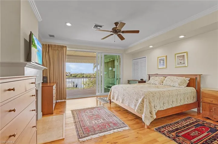 Bedroom featuring access to exterior, light wood-type flooring, ceiling fan, and crown molding