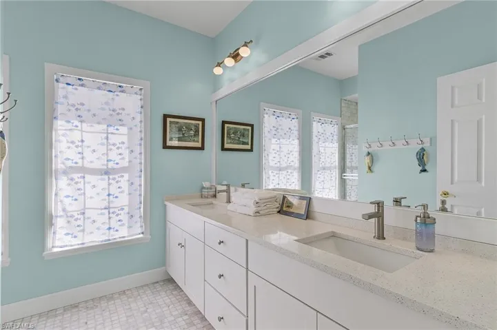 Bathroom with vanity, walk in shower, and a wealth of natural light
