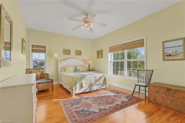Bedroom with multiple windows, ceiling fan, and light hardwood / wood-style flooring