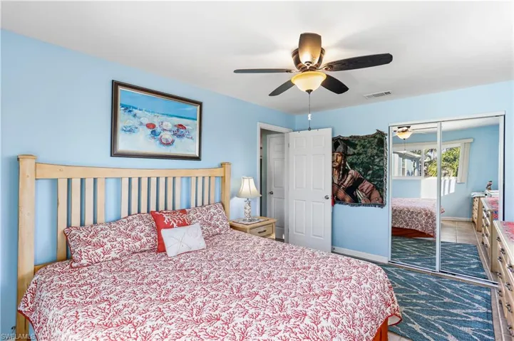 Tiled bedroom featuring ceiling fan and a closet
