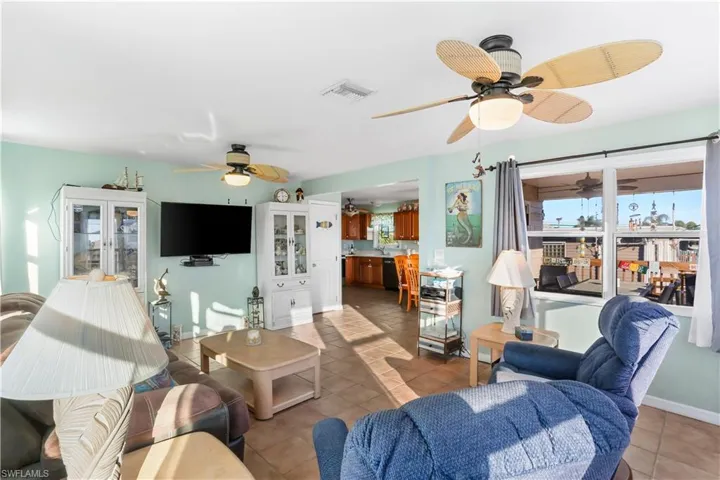Living room with tile patterned floors and ceiling fan