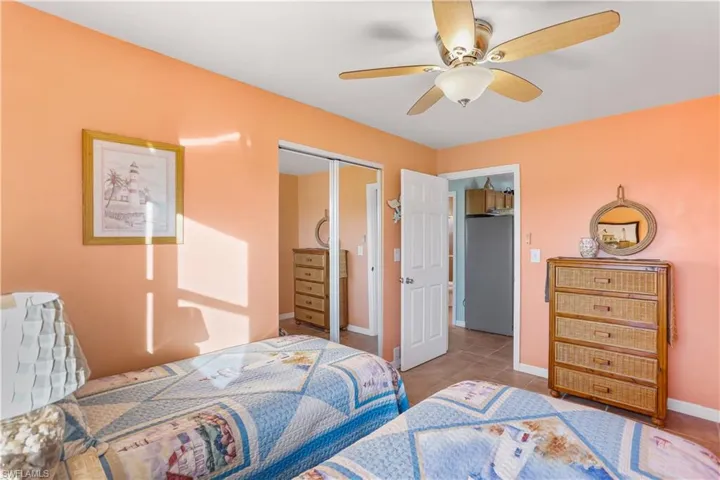 Bedroom with ceiling fan, a closet, and light tile patterned floors