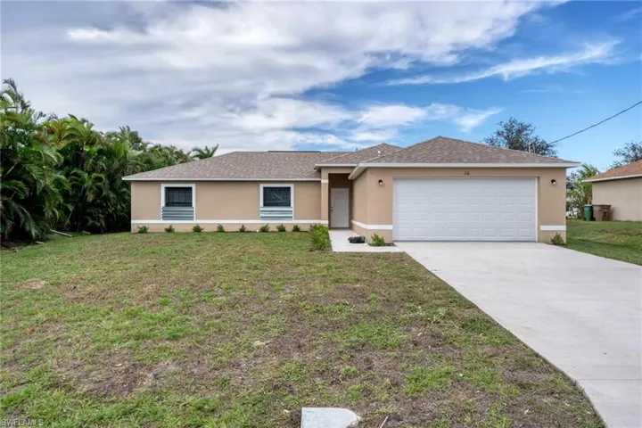 Ranch-style house with a garage and a front lawn