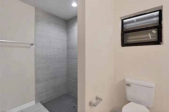 Bathroom featuring a tile shower and toilet