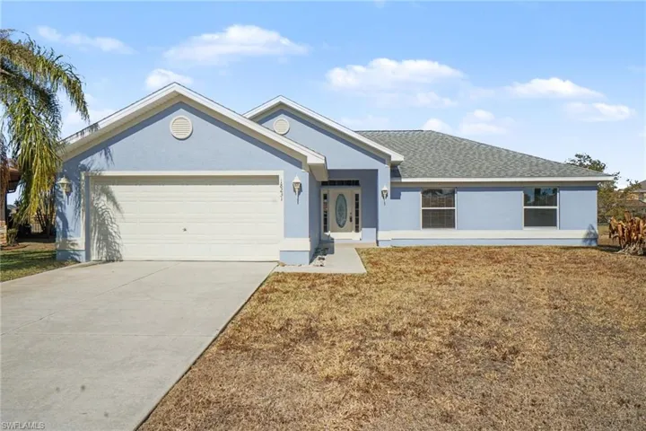 Single story home featuring a front yard, stucco siding, concrete driveway, a garage, and roof with shingles