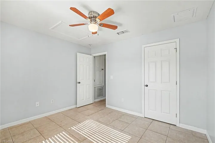 Unfurnished bedroom with light tile patterned flooring and ceiling fan