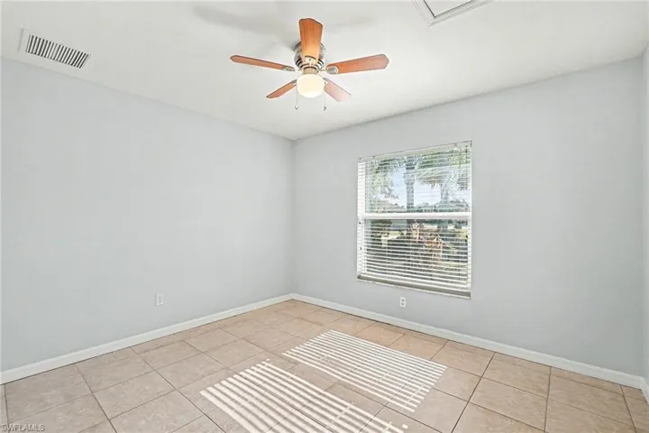 Unfurnished room with ceiling fan and light tile patterned floors