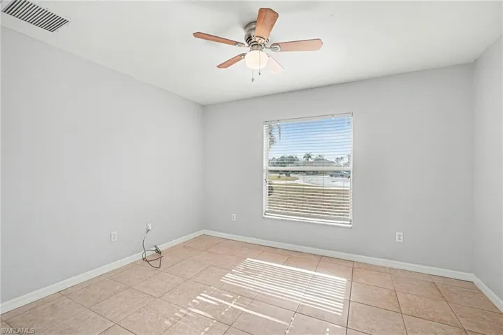 Unfurnished room with ceiling fan and light tile patterned floors