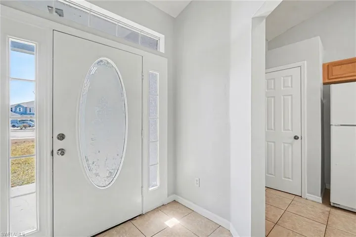 Foyer entrance featuring light tile patterned floors