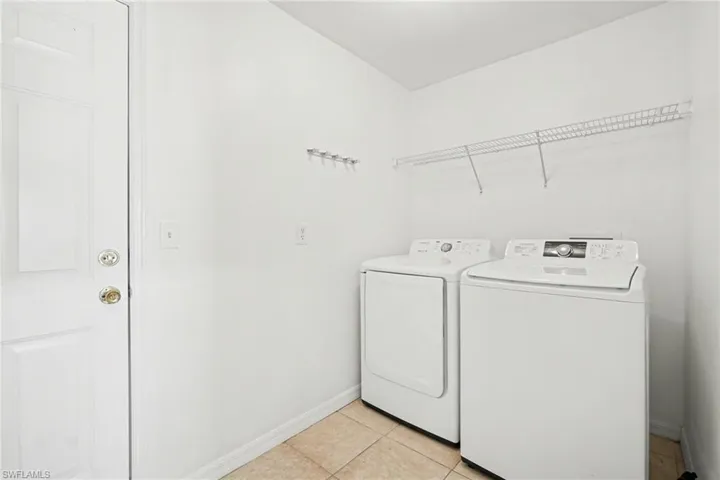 Laundry room featuring light tile patterned floors and washing machine and dryer