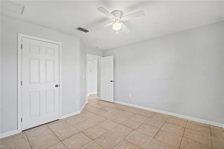 Unfurnished bedroom with ceiling fan and light tile patterned floors
