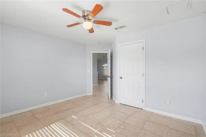 Unfurnished room with ceiling fan and light tile patterned floors