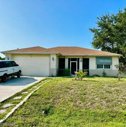 Ranch-style house featuring a front yard and a garage