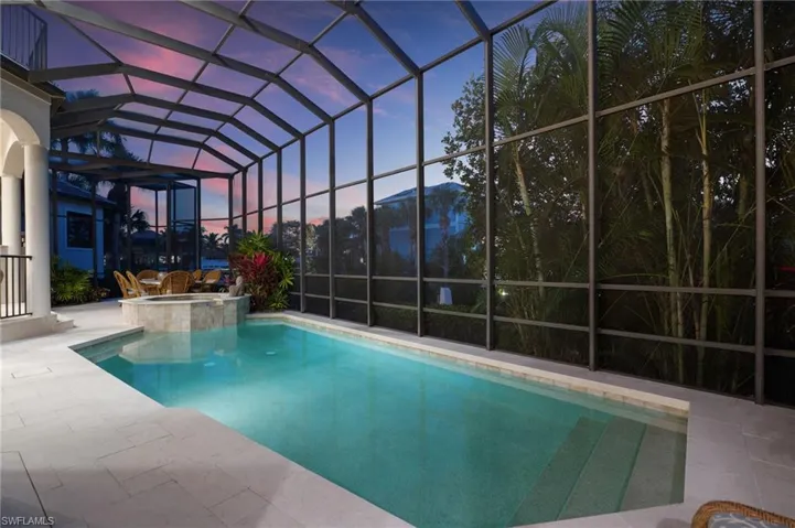 Modernized pool deck/patio with premium travertine pavers & new railings.