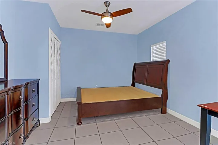 Bedroom with ceiling fan and light tile floors