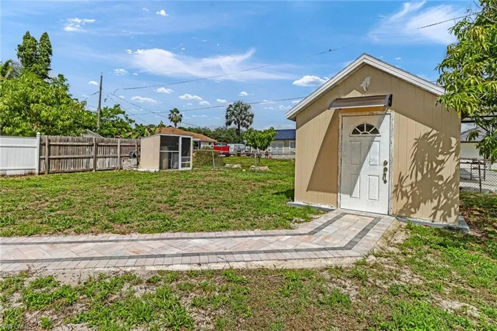 View of outdoor structure featuring a lawn