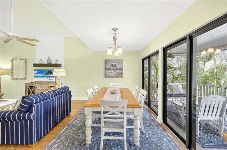 Dining space featuring wood finished floors, a ceiling fan, and a chandelier