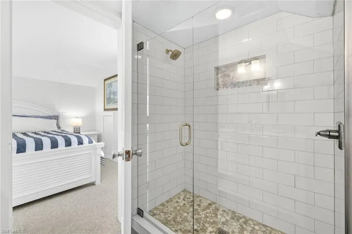 Full bathroom featuring ensuite bath and a shower stall