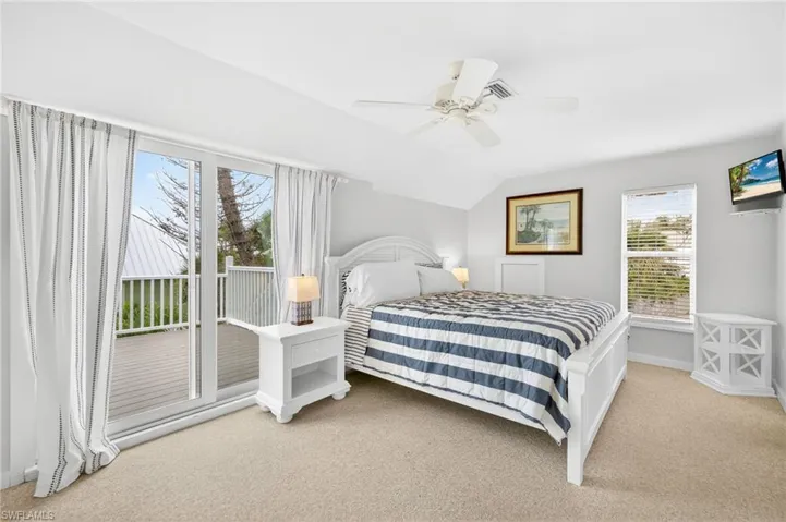 Bedroom with carpet floors, lofted ceiling, access to outside, and ceiling fan