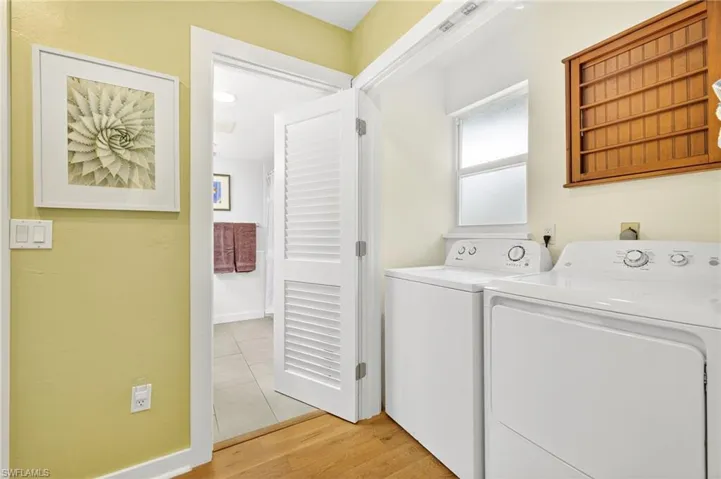 Laundry room with washer and dryer and light wood-style floors