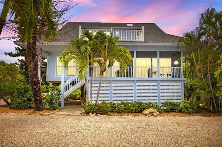 Raised beach house with stairs and roof with shingles