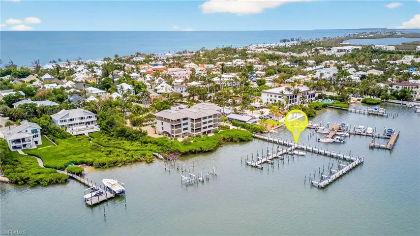 Aerial perspective of suburban area with a nearby body of water and a marina